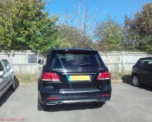 image of a black car in a car park